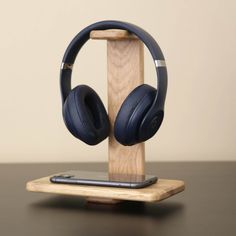 an iphone and headphones on a wooden stand