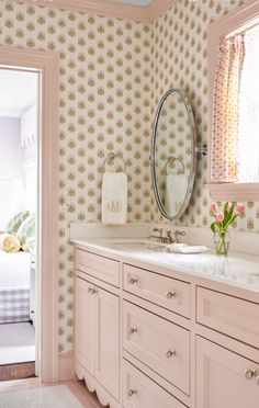 a bathroom with two sinks and a mirror on the wall next to a bed in a room