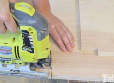 a person using a power tool to cut plywood planks with a jig saw