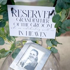 there is a sign that says reserved grandfather of the groom in heaven on top of a vase filled with greenery