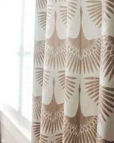 a window with a curtain that has leaves on it and is next to a radiator