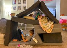 two children are playing in an inflatable bed with a tent on the floor