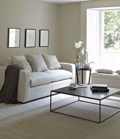 a living room with two couches, a coffee table and pictures on the wall