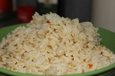 a green bowl filled with rice on top of a table