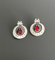 "About this Item: these sterling silver handcrafted pomegranate earrings are truly unique. the pomegranate fruit is often seen as a symbol of femininity and fertility, and these earrings feature a stunning red crystal that complements the fruit's vibrant color. not only are they stylish,but they are also comfortable to wear and add a pop of color to even the simplest outfits.  Materials: 925 Sterling silver, red Crystal Weight: 0.20 oz ( 5.9 gr )  I believe that jewelry is not just a decorative accessory, but a meaningful and profound object that carries deep beauty and significance within. The true beauty originates in our minds and thoughts before it is reflected in our appearance, and that is precisely why I chose the name Baavaar for my brand. Baavaar means \"believe\" in my native Far Pomegranate Earrings, Pomegranate Fruit, Dainty Studs, Red Crystals, Gift Birthday, Fertility, Jewelry Earrings Studs, Pomegranate, Earrings Handmade