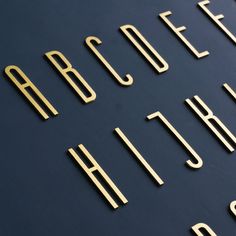 the letters and numbers are made out of gold metal pieces on a blue surface with black background