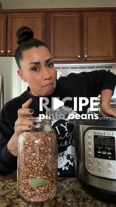 a woman in black shirt standing next to an instant pot filled with beans