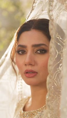 a woman in a white dress and veil looking at the camera with an intense look on her face