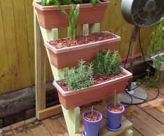 three planters are stacked on top of each other with plants growing out of them