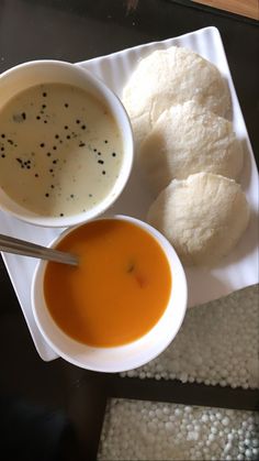 two bowls of soup and bread on a plate