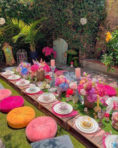 a table set up with plates and place settings for an outdoor dinner in the garden