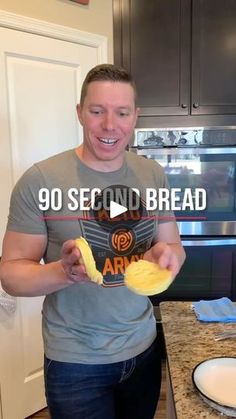 a man standing in front of a kitchen counter holding an item with the words 90 second bread on it