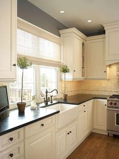 a kitchen with white cabinets and black counter tops is featured in the instagramm app