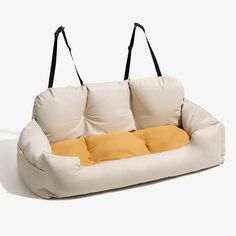 a white couch with two yellow pillows hanging from it's back and on the side