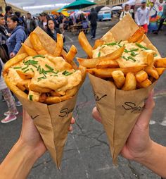 two people holding up some food in their hands