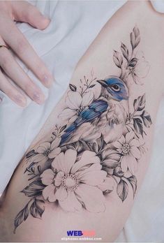 a woman's thigh with flowers and a bird on it