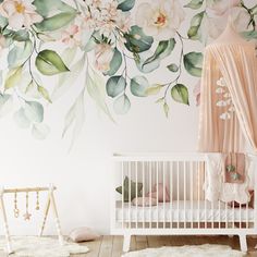 a white crib in front of a floral wall mural