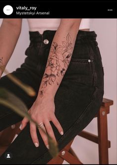 a woman with tattoos on her arm sitting in a chair