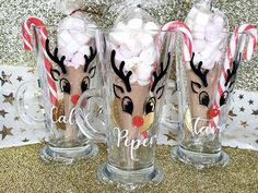 three glass mugs decorated with candy canes and candies are sitting on a table