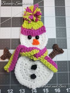 a crocheted snowman ornament with a hat and scarf on it