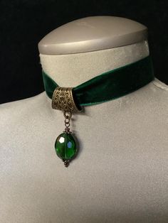 Green Velvet Choker! "Add a touch of elegance to your look with this **green velvet choker featuring a stunning **emerald green crystal** at its center. Perfect for the festive season, this **Christmas choker** makes a beautiful statement as **Christmas jewelry** or as a sophisticated **bridal accessory**. The choker is **adjustable** for a comfortable fit, making it an ideal piece for both **bridal jewelry** and holiday celebrations. Crafted with luxurious velvet, this choker exudes timeless charm and style for any occasion." This description highlights the versatility and elegance of the choker for both festive and bridal wear.... *This very elegant "green velvet choker" measures 12" in length....the crystal measures 3/4" in height, and 1/2" in width....if you would prefer to have this c Vintage Jeweled Choker As Gift, Vintage Jeweled Choker Gift, Adjustable Jewelry For May Birthstone Party, Vintage Jeweled Choker For Parties, Vintage Green Choker Necklace, Elegant Adjustable Christmas Necklaces, Elegant Adjustable Emerald Necklace Gift, Elegant Christmas Adjustable Necklace, Elegant Adjustable Green Choker