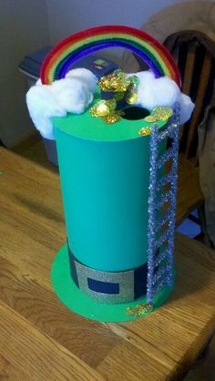 a green top hat with rainbows and clouds on it sitting on a wooden table