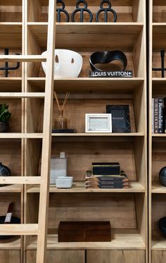 a wooden book shelf filled with lots of books and other items on top of it