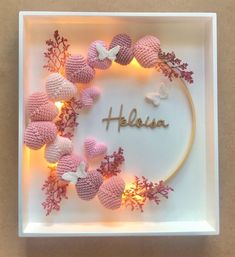 a crocheted wreath with the word helisa surrounded by flowers and butterflies