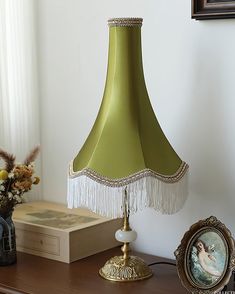 a lamp that is on top of a table next to a vase with flowers in it