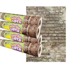 three rolls of toilet paper sitting on top of each other in front of a brick wall