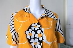 Beautiful True Vintage blouse from the 1970s. Comfortable fabric, probably cotton. Amazing floral and stripes print and a large pointed collar! Button down. Two front pockets. Vented on the sides. Made in Sweden! BRAND: Unella Stockholm ERA: 1970s COLOR: Yellow, white, black FABRIC: No fabric tag, probably cotton SIZE: Vintage size 46, fits best size M to small L - please check measurements below MEASUREMENTS: Pit to pit 49cm, total length 75cm CONDITION: Very good Vintage condition, small stain Collared Retro Blouse With Retro Print, Collared Retro Print Blouse, Retro Blouse With Peter Pan Collar, Retro Cotton Blouse With Floral Print, 1970s Cotton Blouse For Spring, 1970s Style Cotton Blouse For Spring, Retro Cotton Blouse With Retro Print, Cotton Retro Blouse With Retro Print, Vintage Cotton Blouse With Collared Neckline