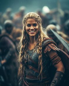 a woman with long blonde hair and braids smiles while standing in front of other people