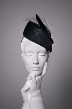 Sara is a felt percher hat, made from beautiful high-quality velour felt.   This elegant cocktail hat is finished with a modern feather detail. The hat modelled is shown in 'Midnight'.  The hat can also be made in lots of additional colours*. This hat is high at the crown and would suit the following face shapes: oval, round, square, and heart.  Please ask if you would like advice on styling before purchasing. Hat Details: * The hat secures with a metal comb and millinery headband, this can be d Modern Halo Hats, Luxury Elegant Flat Bill Hat, Evening Feathered Hat Headpiece, Evening Feather Hat Headpiece, Evening Hat With Feathers, Feather Trim Mini Hats For Kentucky Derby Evening, Evening Mini Hat With Feathers And Short Brim, Kentucky Derby Evening Mini Hat With Feather Trim, Adjustable Evening Hat With Feather Trim