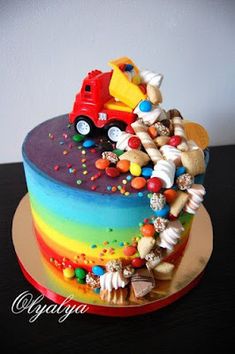 a rainbow colored cake with lots of candy on top