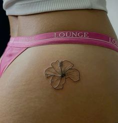 a woman's stomach with a flower tattoo on it