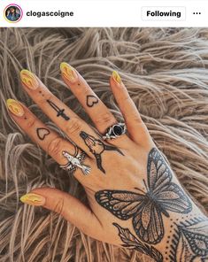 a woman's hand with tattoos on it