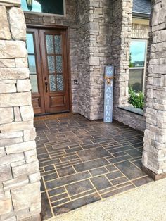 the front entrance to a home with stone pillars and doors on both sides, along with a sign that says welcome