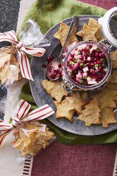 a silver plate topped with crackers and pomegranates on top of a table