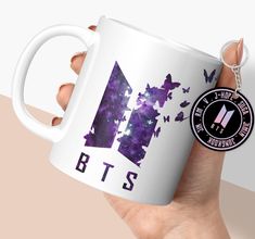 a hand holding a white coffee mug with the letter b is for bt's on it