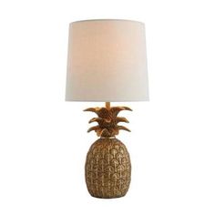 a gold pineapple lamp with a white shade