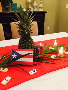 a pineapple sitting on top of a table next to candles