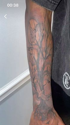 a man with a tree tattoo on his arm