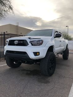 a white toyota truck parked in a parking lot