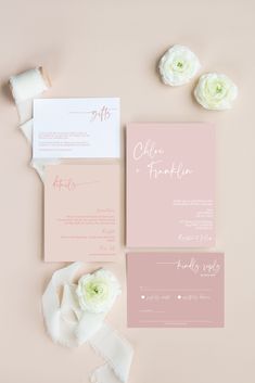 the wedding stationery is laid out on top of each other, with flowers and paper