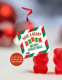 some red gummy bears are sitting next to each other with a merry christmas tag on them