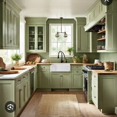 a kitchen with green cabinets and wooden floors