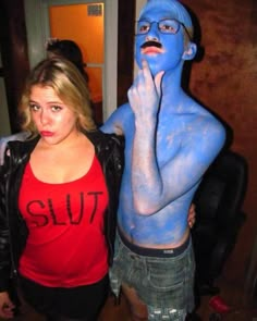 two people with blue paint on their bodies and one is holding his hand to his face