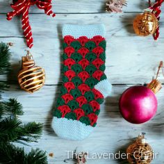 a crocheted christmas stocking next to ornaments on a wooden background with text overlay