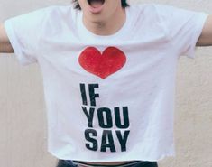 a young man with his hands in the air while wearing a t - shirt that says if you say