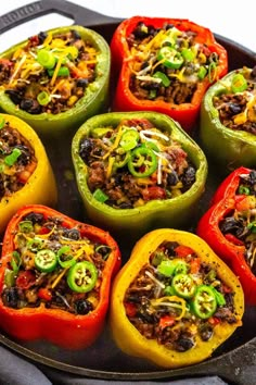 peppers stuffed with ground beef, black beans and green peppers in a cast iron skillet